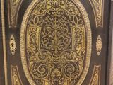 an antique wooden cabinet with a gold and black design on it