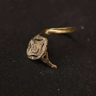 un gros plan d'une bague en or posée sur un tissu noir