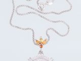 collier en argent avec une pierre rose et un oiseau suspendu à une chaîne