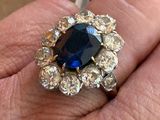 une personne tenant une bague sertie d'une pierre bleue