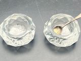 two clear glass bowls with spoons on a table