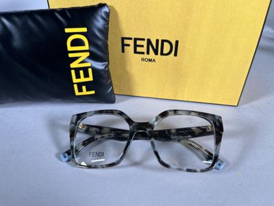 une paire de lunettes posée sur une table, à côté d'un oreiller