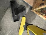 a yellow vacuum that is on the floor next to a painting