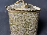 une boîte ancienne en laiton sur laquelle est perché un oiseau