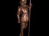 a bronze statue of a man holding a spear and a flag