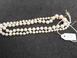 a close up of a white pearl necklace with a tag on it