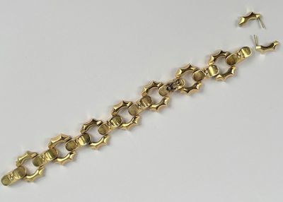 gros plan d'un bracelet en or sur une surface blanche