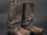 an old pair of brown leather boots on a black background