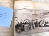 un livre sur lequel figure l'image d'une usine accompagnée d'une note