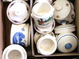 une boîte en carton remplie de toutes sortes de tasses et de soucoupes
