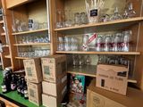 de nombreuses boîtes et verres posés sur une étagère dans une pièce