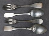 trois cuillères en argent et deux cuillères en argent sur une table