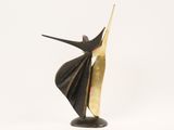 bronze sculpture of a woman in a black and gold dress with her arms outstretched
