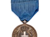 une vieille médaille ornée d'une croix, suspendue à un ruban bleu