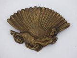 une image représentant une plaque en laiton sur laquelle figure une dame tenant un éventail
