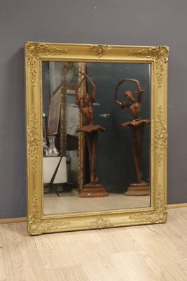 un grand miroir dans lequel on voit la statue d'un homme et d'une femme
