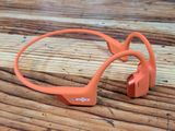 a pair of orange headphones sitting on a wooden table