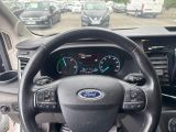 a steering wheel and dashboard of a car in a parking lot