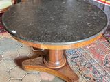 a table with a black marble top sitting on a rug