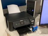 a computer and a printer on a desk in a room