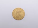 a gold coin on a white surface