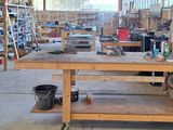 un établi au milieu d'un bâtiment, sur lequel sont posés des outils