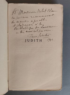 un livre ouvert avec une écriture manuscrite posé sur une table