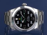 rolex watch with black dial and green hands on a blue background