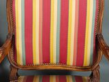 fauteuil rembourré à rayures, avec structure et accoudoirs en bois