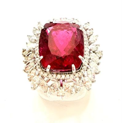 une photo d'une bague en diamant rouge et blanche posée sur une surface blanche