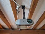 un projecteur fixé au plafond, sur lequel est montée une caméra