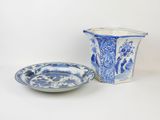 a blue and white vase and a plate on a white surface