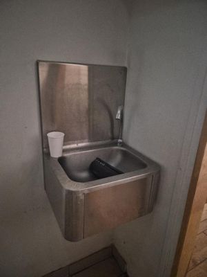 un évier en acier inoxydable dans le coin d'une salle de bains