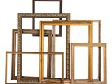 a set of five gold and black picture frames sitting on top of each other