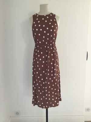 brown and white polka dot dress on a mannequin stand