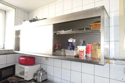 une cuisine équipée d'une cuisinière, d'un micro-ondes et d'autres ustensiles posés sur le plan de travail