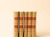 trois livres superposés sur une surface blanche