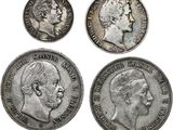 quatre types différents de pièces d'argent, dont l'une représente le visage d'un homme et une autre la tête d'une femme