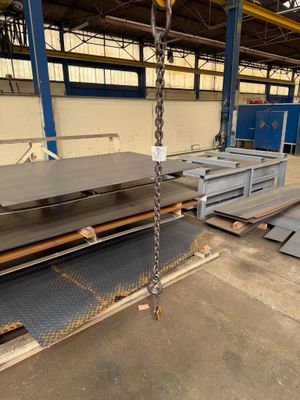 steel plates are stacked on pallets in a warehouse