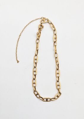 a gold chain necklace with a long link on a white background