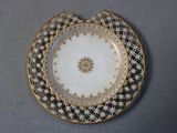 a white plate with gold and black designs on it