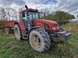 un tracteur rouge garé dans l'herbe