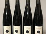 quatre bouteilles de vin sont alignées sur une table