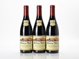 trois bouteilles de vin rouge posées sur une table blanche