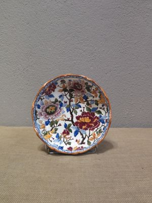 une petite assiette décorée de fleurs, posée sur une table