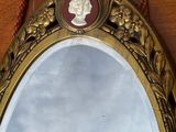 un miroir accroché au mur sur lequel figure le portrait d'une femme