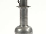 an old silver vase sitting on top of a white surface