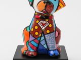 ceramic sculpture of a dog sitting on a black base