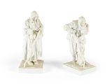 deux statues blanches représentant un homme et une femme tenant un enfant dans leurs bras