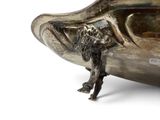 a silver bowl with a dog on it on a white surface